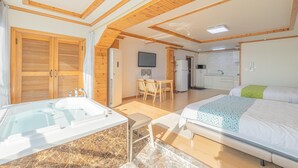 Amplia habitación con una cama grande, una bañera, un comedor y una cocina.