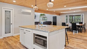 A kitchen with a granite countertop, white cabinetry, a built-in oven, and pendant lighting. - 4 Bedrooms, Sleeps 16, Hot Tub, Games, Tesla Charger, Smart TV's,  MORE! (Heber)