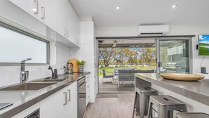 A modern kitchen with a large window, built-in appliances, and a view of the outdoors. - #56 Highview (Moama)