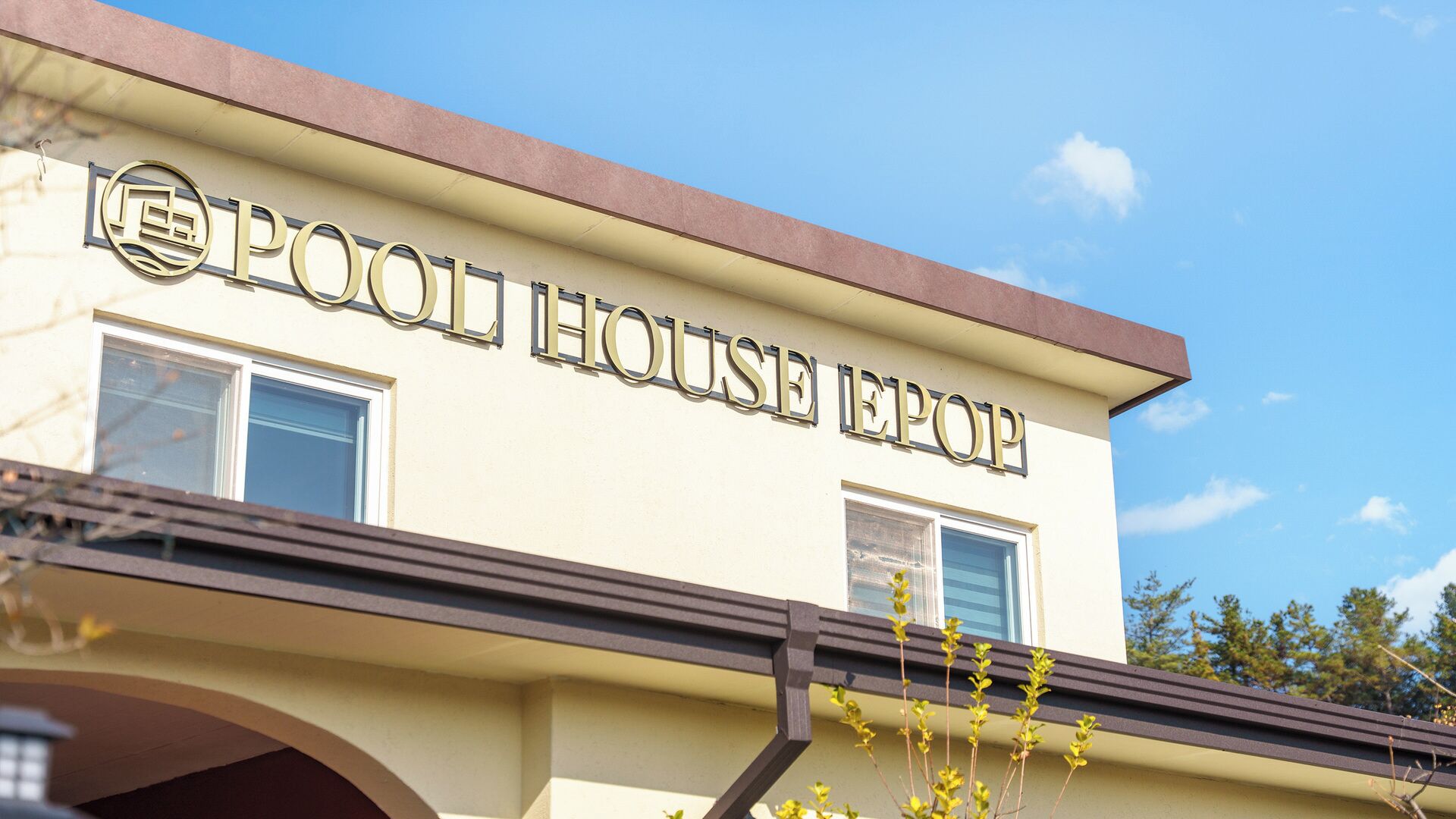 A building with a sign that reads 'POOL HOUSE EPOP.'