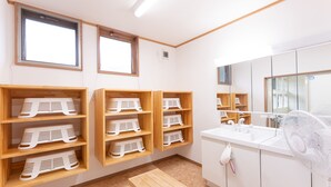 A bathroom with wooden shelves, a sink, a mirror, and a bench. - Hirononomori Maehama Bekkan - Male only (Hirono)