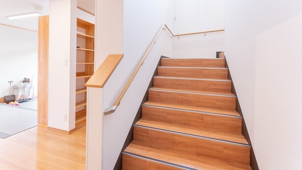 A modern staircase with wooden steps and a metal handrail, leading to a room with white walls and a wooden floor. - Hirononomori Maehama Bekkan - Male only (Hirono)