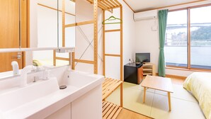 A modern room with a wooden partition, a sink, a desk, a bed, and a view of a body of water. - Hirononomori Maehama Bekkan - Male only (Hirono)