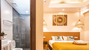 A modern bathroom with a glass-enclosed shower and a toilet with a wooden vanity. - Molly Resort (Puerto Galera)