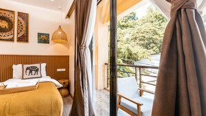 A bedroom with a bed, a wooden headboard, a hanging light fixture, and a balcony with a chair. - Molly Resort (Puerto Galera)