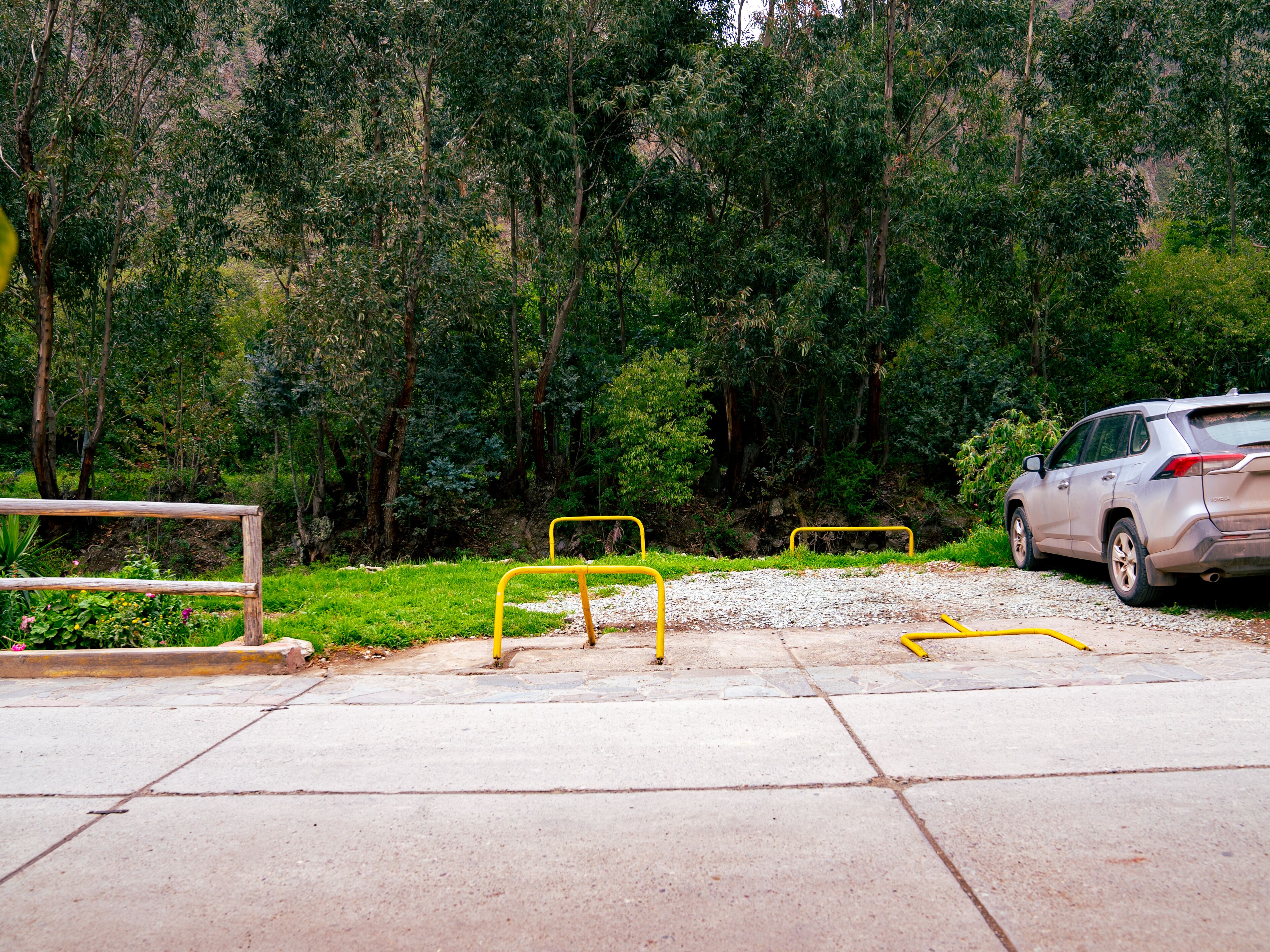 Un estacionamiento con un coche y barreras amarillas.