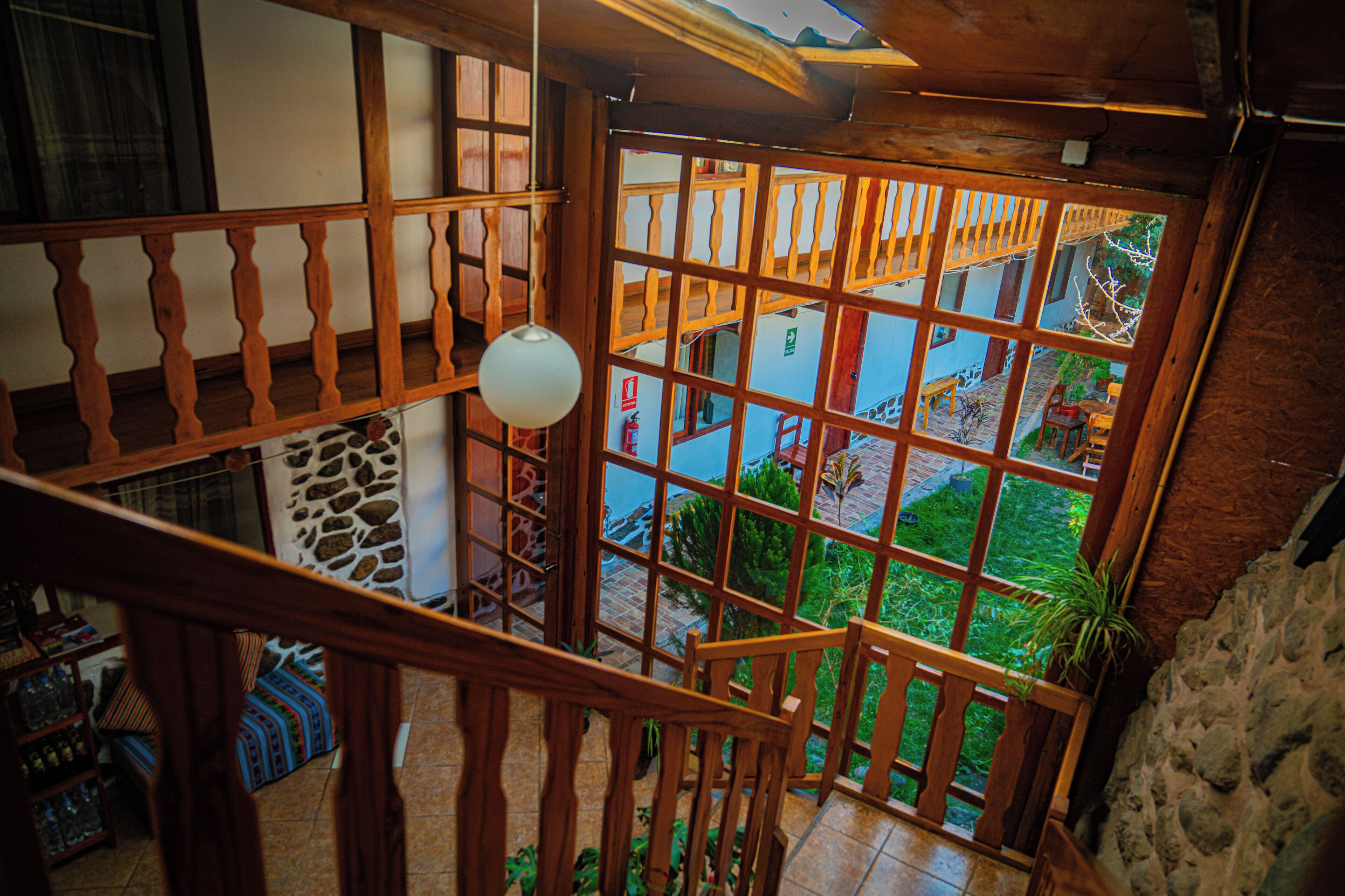 A wooden staircase with a view of a courtyard.
