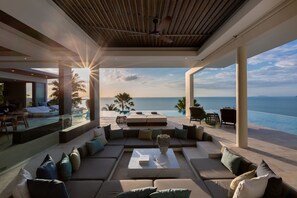 Un espacio exterior moderno con piscina, asientos y vistas al océano.