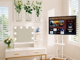 Une pièce équipée d’une coiffeuse, d’un miroir et d’un téléviseur affichant l’interface Roku TV.