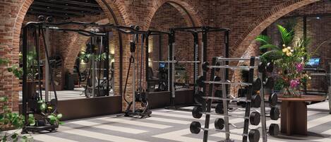 Un gimnasio con paredes de ladrillo, espejos y diverso equipamiento de ejercicio.