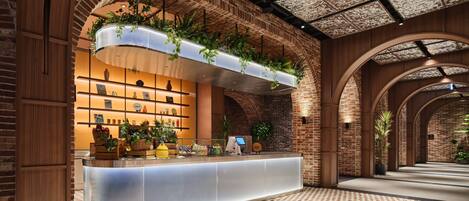 A reception area with a brick wall, a counter with a glass top, and hanging plants.