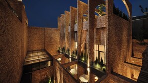 A multi-level brick building with a central atrium, outdoor seating, and a rooftop garden. - ANANTI AT GANGNAM (Seoul)