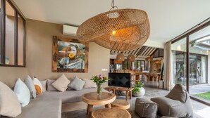 Ein modernes Wohnzimmer mit einer Couch, einem Fernseher und einem großen Fenster.