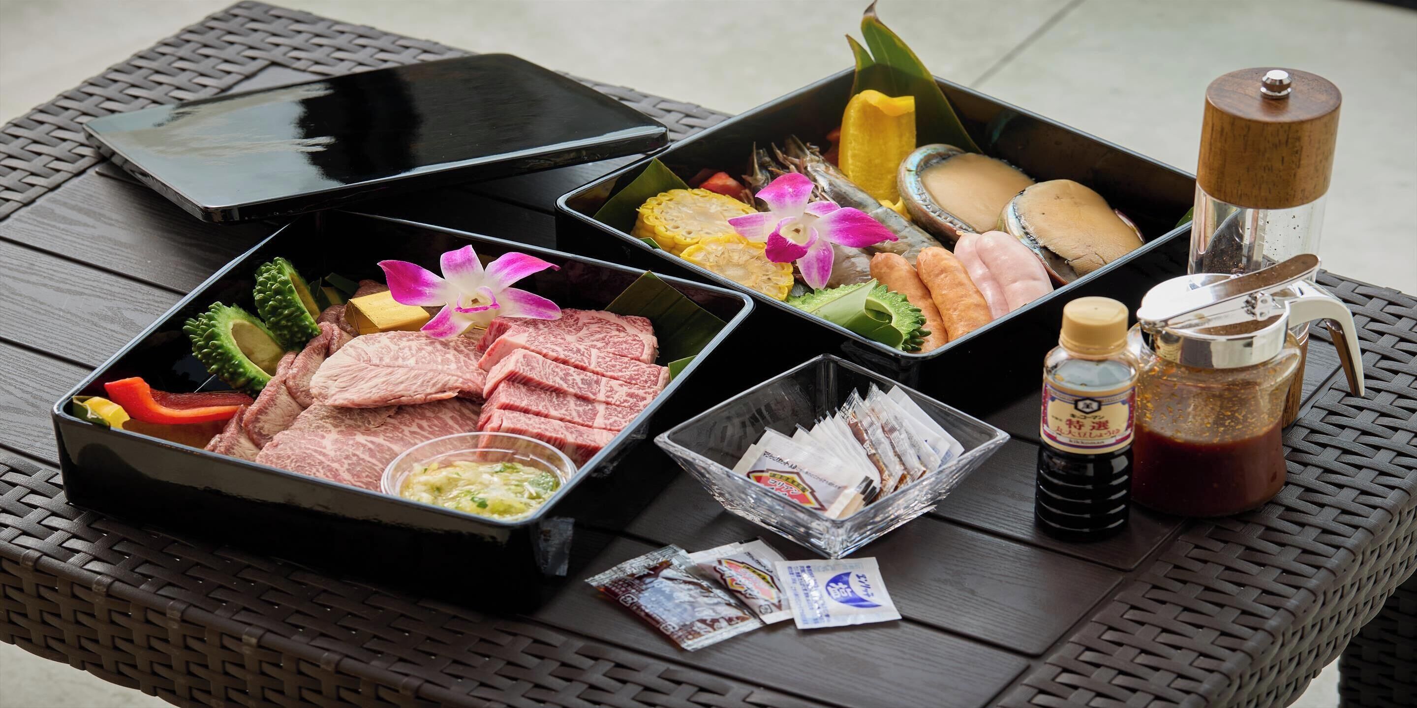 A table with various food items, condiments, and a smartphone.