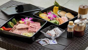 A table with various food items, condiments, and a smartphone.