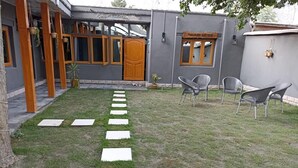A courtyard with a paved walkway, outdoor seating area, and a building labeled "Playa Beach Guest House". - The Vintage Guest House Skardu  (Skardu)