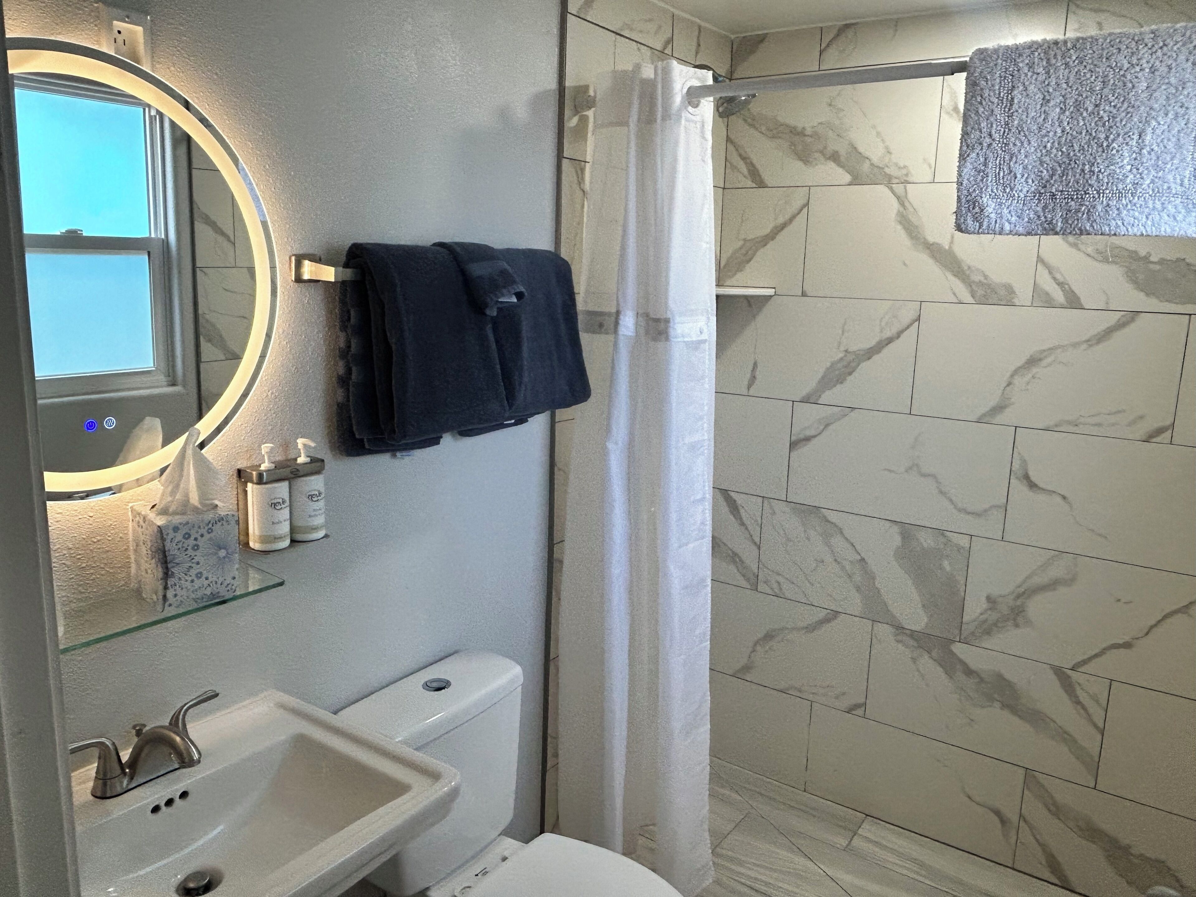 A bathroom with a toilet, sink, and shower curtain.