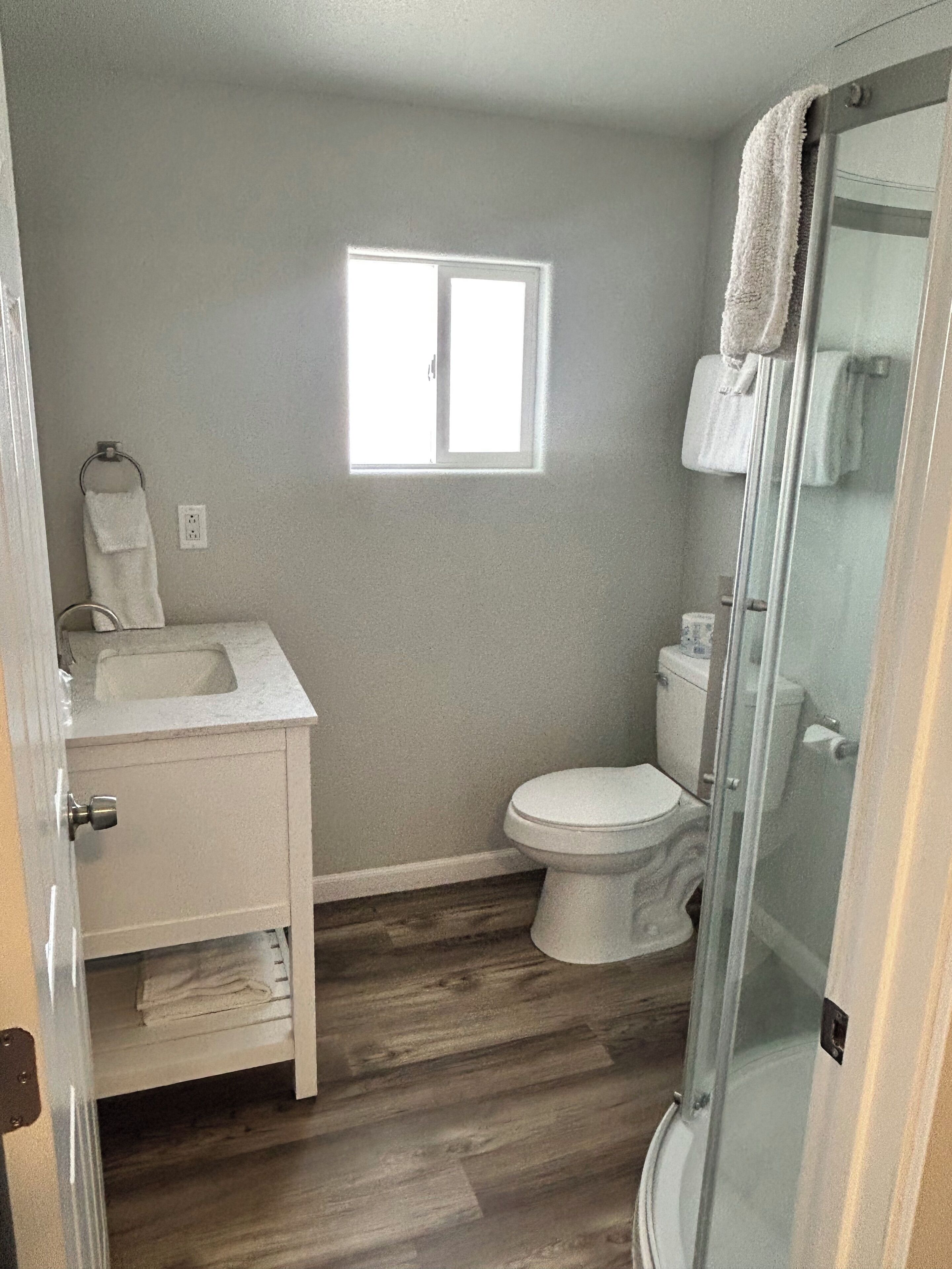Een badkamer met toilet, wastafel en douchehoek.