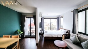 Une chambre d’hôtel avec un lit, un canapé, une table à manger et un téléviseur.