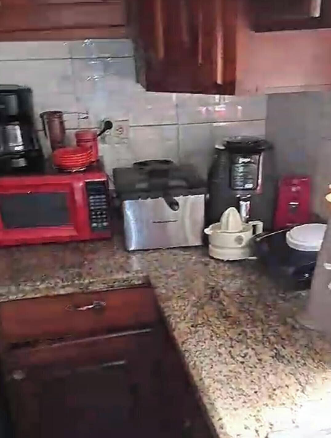Una cocina equipada con microondas, cafetera, tostadora y hervidor.