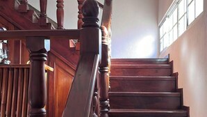 Una escalera de madera con barandilla que lleva a un rellano con ventana.