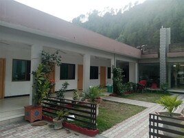 A building with a covered outdoor area, potted plants, and outdoor seating.