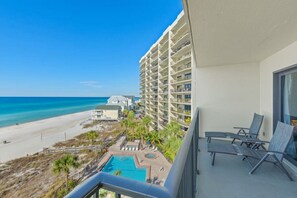 Un balcon d’hôtel avec vue sur la plage et l’océan.