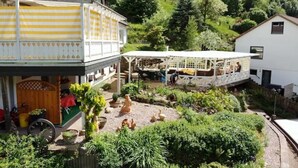 A two-story house with a balcony and a garden area with ducks. - Vacation apartment on a hillside with a picturesque view (Osterode am Harz)