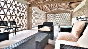 An outdoor seating area with wicker furniture and a lattice wall. - Entire Tuscan farmhouse with private pool between Siena and Florence (San Gimignano)