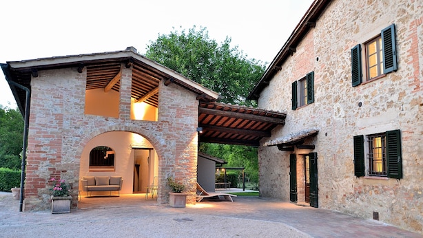 A rustic stone building with an arched entrance, a covered patio area, and a seating arrangement. - Entire Tuscan farmhouse with private pool between Siena and Florence (San Gimignano)