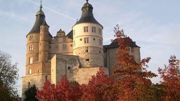 Un château historique doté de nombreuses tours, dont une tour centrale ronde particulièrement imposante.