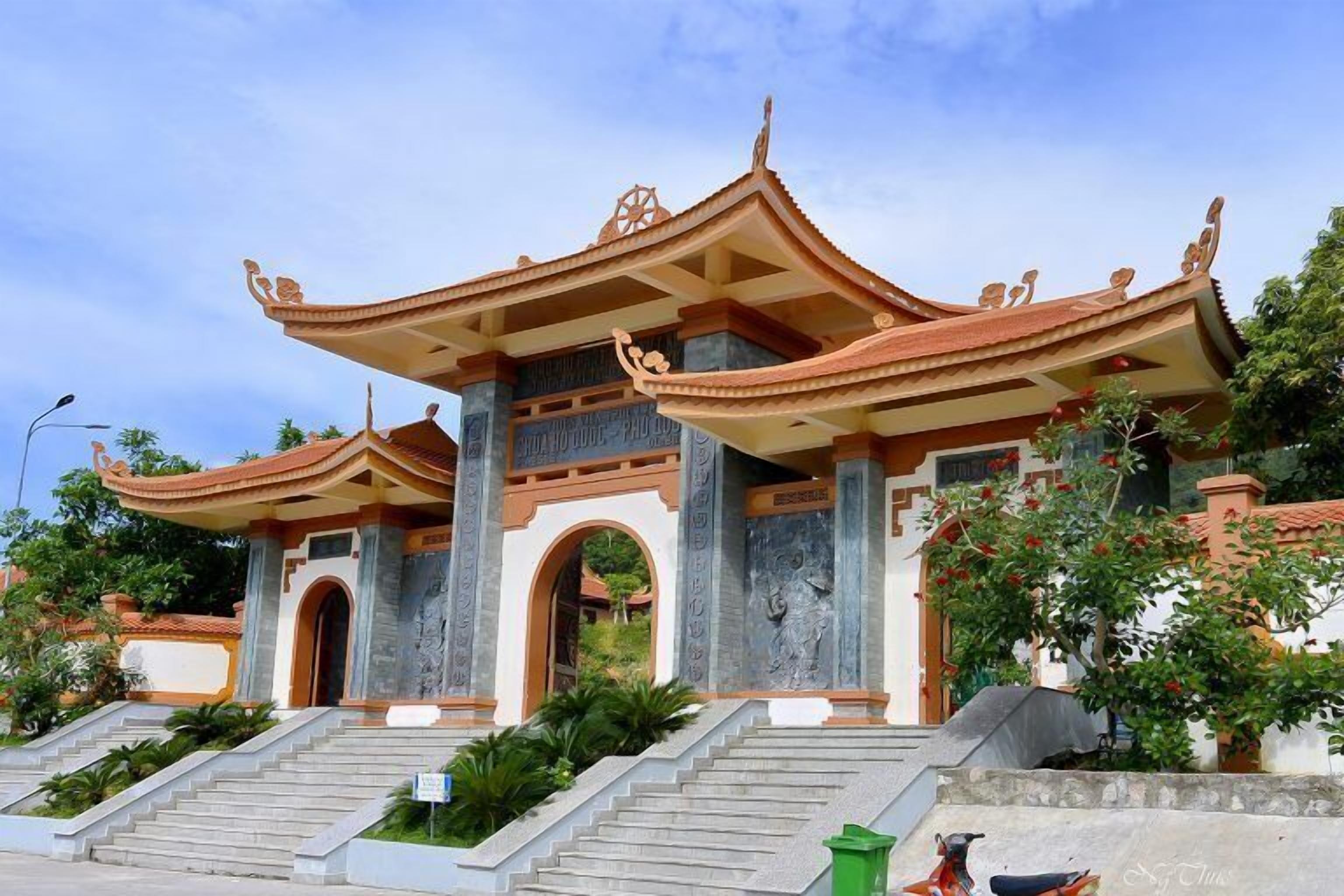 Un temple traditionnel doté d’un toit à plusieurs niveaux, d’un escalier en pierre menant à l’entrée et de gravures sur les murs.