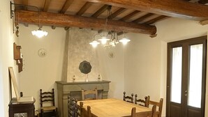 Ein Essbereich mit Holztisch und -stühlen, einer Kandelaber und einem Fliesenboden.