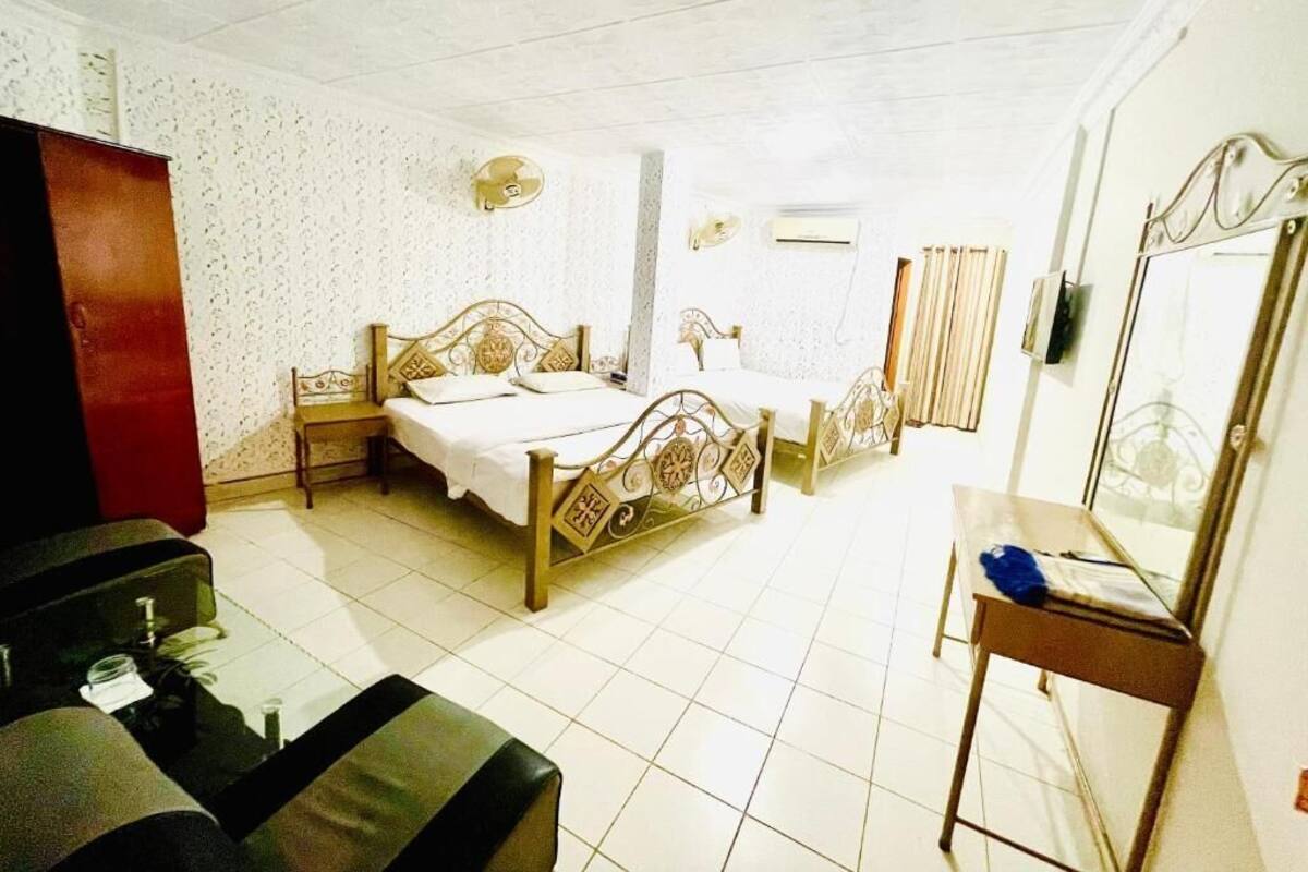 A room with two beds, a desk, and a wardrobe.