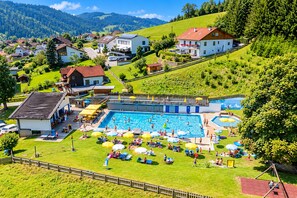 A swimming pool complex with multiple pools, sun loungers, and umbrellas.