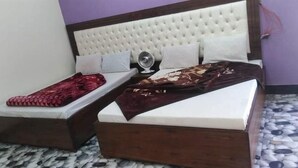 A bedroom with two beds, a white headboard, and a patterned floor. - Mezban Hotel & Restaurant (Balakot)