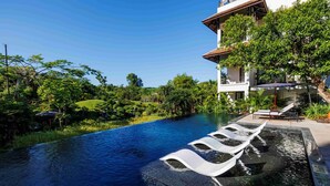 A swimming pool with tiered seating and a lush green landscape. - aNhill Boutique (Hue)