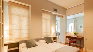 A hotel room with a large bed, bedside tables, a desk, and a mirror. - PRADA PENTHOUSE (terrace, free WIFI, A/C, central, spacious, bright, elegant) (Sevilla)