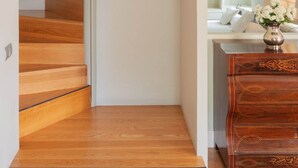 A staircase with wooden steps leading to a second floor, a framed picture on the wall, and a wooden dresser with drawers. - PRADA PENTHOUSE (terrace, free WIFI, A/C, central, spacious, bright, elegant) (Sevilla)