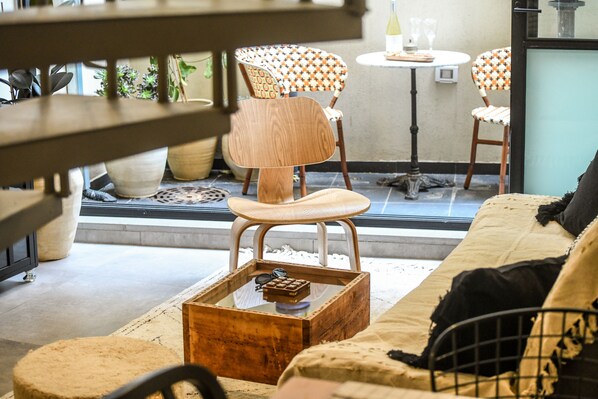 Una sala de estar acogedora con una mesa de centro de madera, un banco acolchado y sillas estampadas.