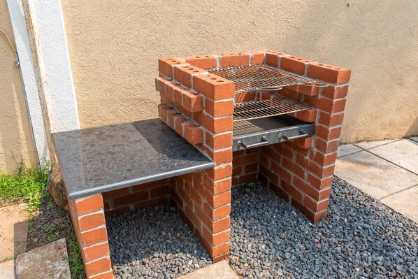 Una barbacoa de totx construïda amb una superfície plana i una reixa metàl·lica.