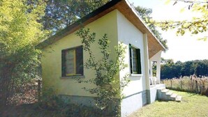 A small, single-story building with a sloped roof, a small porch, and a set of steps leading to the entrance.