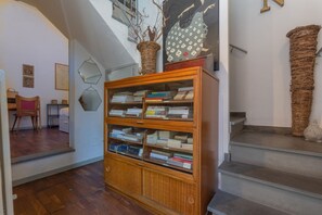 A wooden bookcase with books, a staircase, and a wall with a geometric pattern.