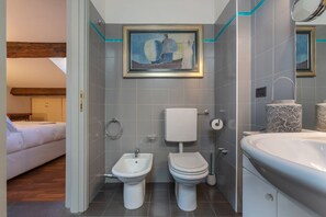 Tina con regadera, secadora de cabello, bidet, toallas 