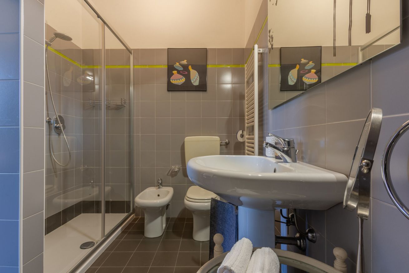 Une salle de bain moderne dotée d’une douche à parois de verre, d’un bidet, de toilettes et d’un lavabo avec un porte-serviettes.