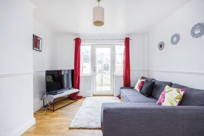 Relax in this stylish living room with a sofa, flat-screen TV, and decorative mirrors.