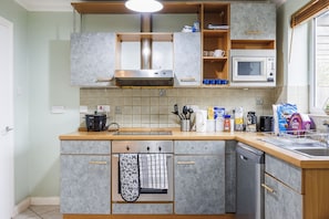 Enjoy cooking in this well-equipped kitchen with a central island, stove, and oven.