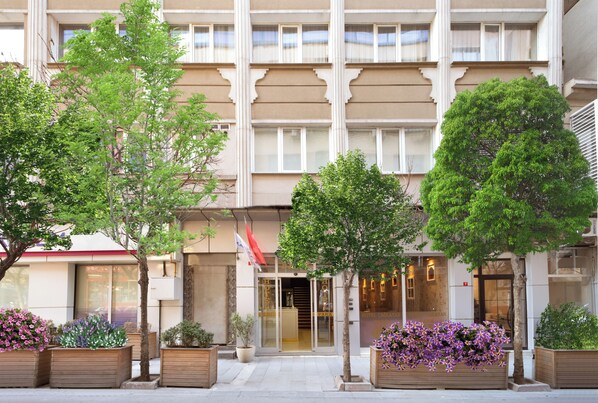 A hotel entrance with a modern facade, large windows, and a welcoming entrance.