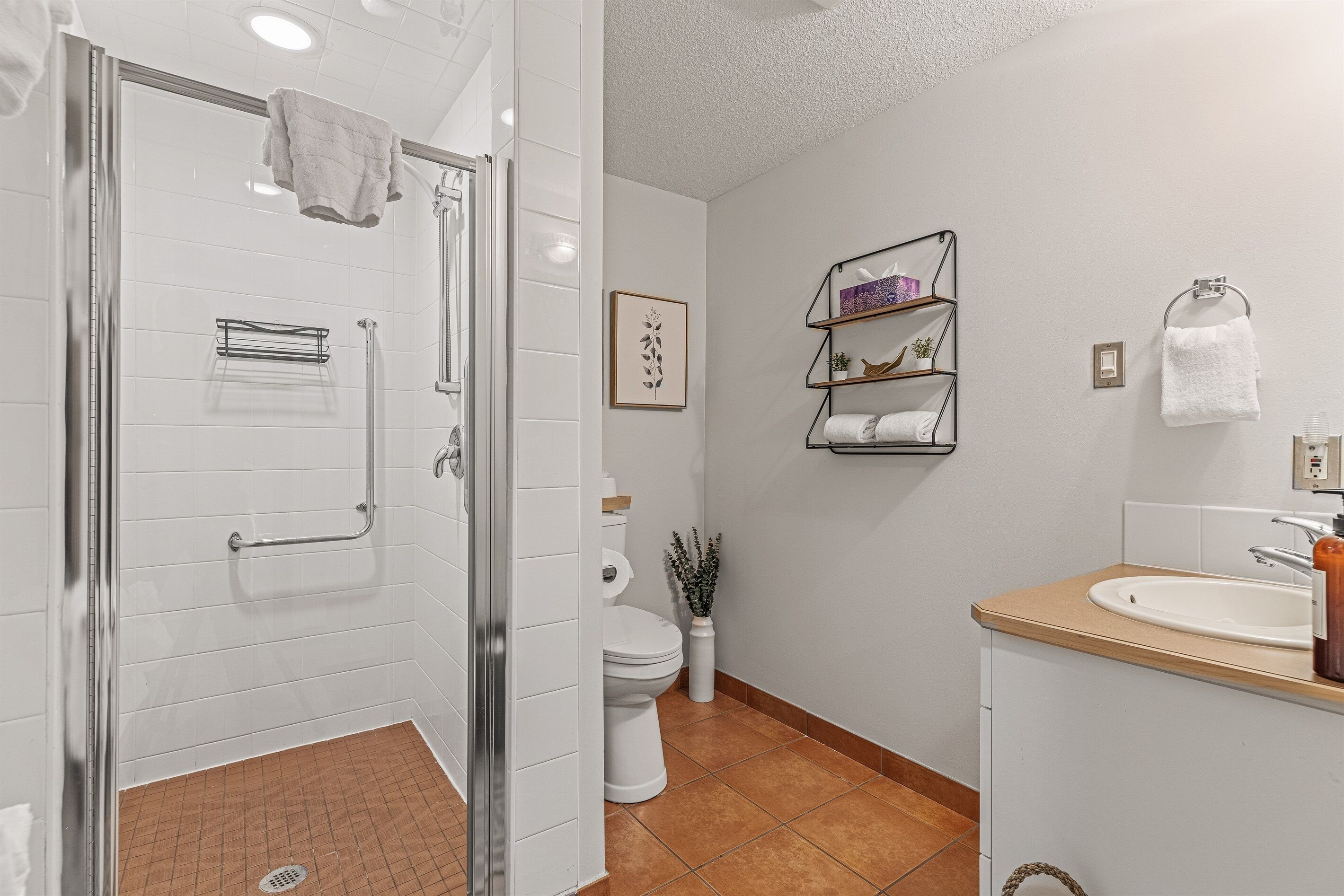 Un baño moderno con ducha, inodoro y lavamanos.