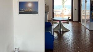 Amplio espacio habitable con una mesa de comedor y sillas, un sofá, y vistas al exterior.